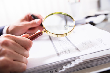 Businessperson Checking Bill With Magnifying Glass