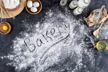 top view of bakery lettering made of flour and various ingredients for baking on dark surface