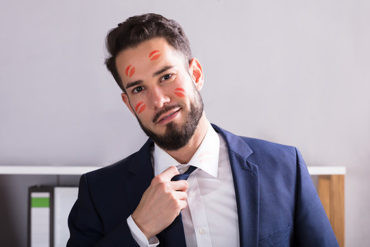Businessman With Lipstick Kiss Marks On Face