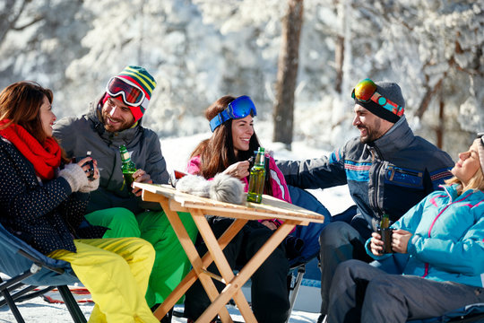 Friends spending time together and drink after skiing in cafe at ski resort