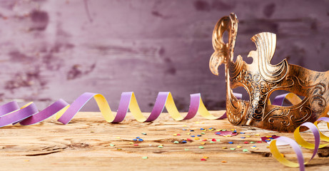 Golden carnival mask banner with party streamer