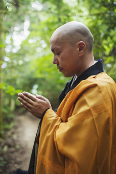 Side view of Buddhist monk with shaved head  meditating