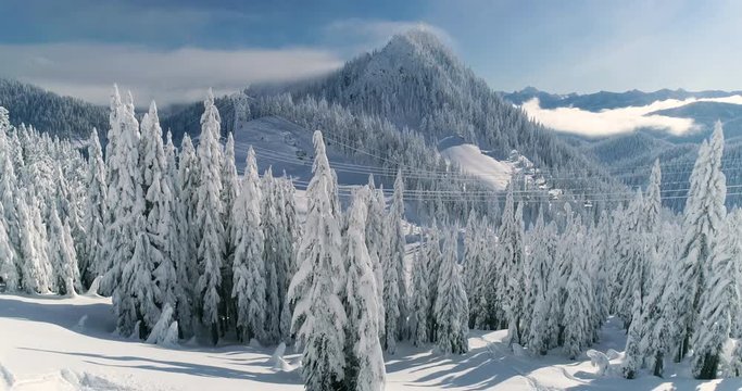 Skiing Concept Mountain Peak Drone View Dropping to Reveal Skier Hiking Up Through Deep Powder Snow