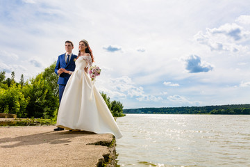 Fototapeta na wymiar Beautiful couple newlyweds near the lake