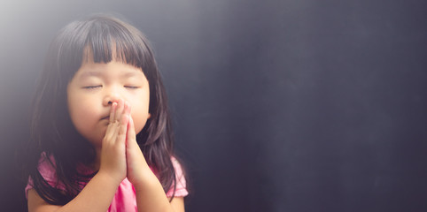 Little girl praying in the morning.Little asian girl hand praying,Hands folded in prayer concept...
