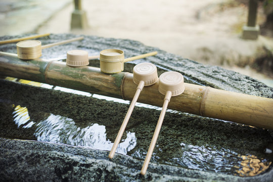 Close up of bamboo water hand washing basins at Shinto Sakurai Shrine, Fukuoka, Japan.