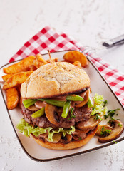 Meat burger with salad, mushrooms, fried potatoes