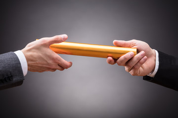 Person Passing Baton To Businessperson