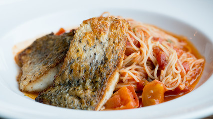 Grilled sea bass and spaghetti with tomato sauce