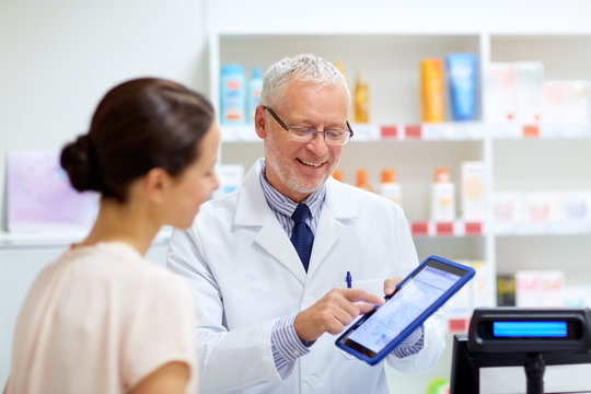 apothecary and customer with tablet pc at pharmacy