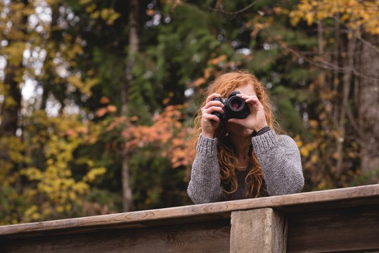 Woman photographing in the autumn forest