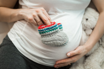 pregnant girl holding booties