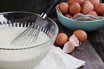 Bowl of homemade pancake batter mix with farm fresh brown eggs in background. Extreme shallow depth...