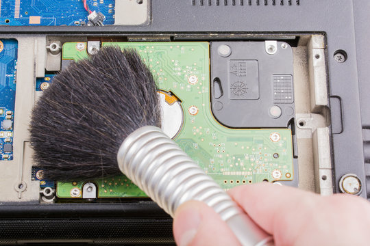 Cleaning the hard drive with a brush from dust