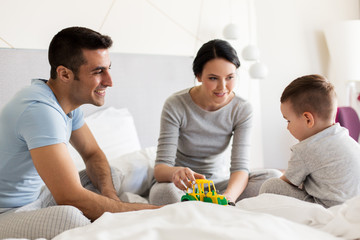 Fototapeta premium happy family in bed at home or hotel room