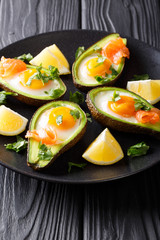 Healthy food baked avocado stuffed with egg and red fish closeup. vertical