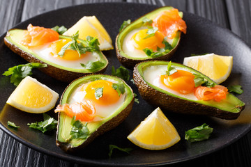 Healthy breakfast: Baked avocado with egg and salmon closeup. horizontal