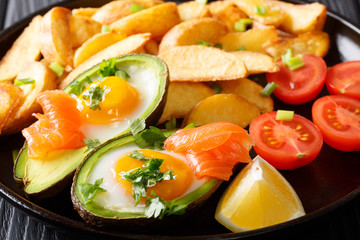 Avocado stuffed with eggs and salmon, fresh tomatoes and fried potato wedges close-up. horizontal
