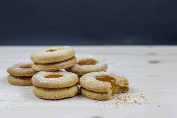 Delicate shortbread cookie with apricot marmalade on a wooden table  Minimal baking concept. 