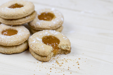 Delicate shortbread cookie with apricot marmalade on a wooden table  Minimal baking concept. 