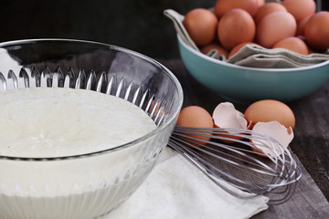 Bowl of homemade pancake batter mix with farm fresh brown eggs in background. Extreme shallow depth of field. Perfect for Shrove Tuesday.