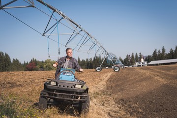 Farmer driving land vehicle in field