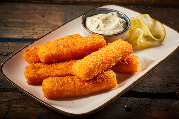 Crispy fried fish fingers served on plate