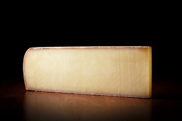 a large piece of Swiss cheese on a black background. side view. Milk product from cow's milk.
