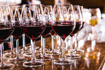 Glasses with red wine on blurred background.
