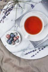 Cup of black tea on a book on the marble tray in bed at morning