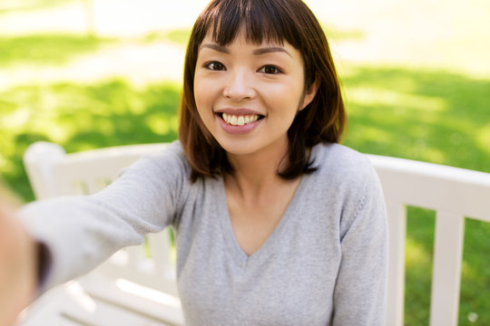 Happy Smiling Asian Woman Taking Selfie At Park