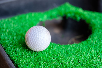 Golf ball edge hole cup on lawn