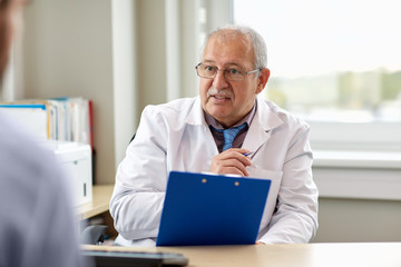 Fototapeta premium senior doctor talking to male patient at hospital