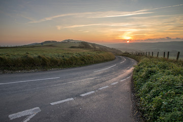 road over hills at sunrise
