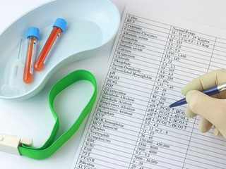 the doctor analyzes blood tests, test tubes with blood lie in the tray, near the syringe and a...