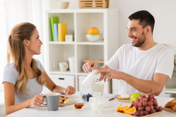 Obraz na płótnie Canvas happy couple having breakfast at home