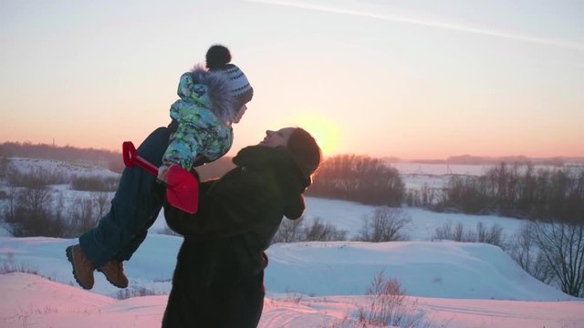 A young girl with a child playing in winter Park.Walks in the fresh air. Sunset