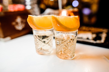 two crystal glasses with whiskey decorated with orange slices