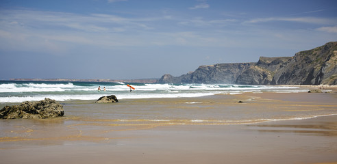 Wild beach on a rough ocean with a rocky cliff. Costa Vincentina. Portugal.