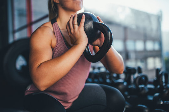 Woman doing workout with kettlebell in gym