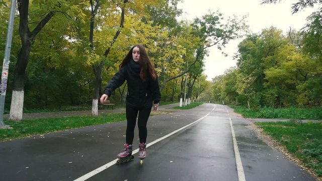 Young Woman On Roller Skates among beautiful autumn trees