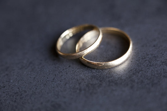 Gold wedding rings on dark background