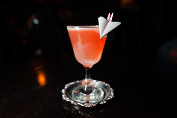 alcoholic cocktail of pink color stands on a special plate