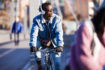 Handsome young man riding bike in the street.