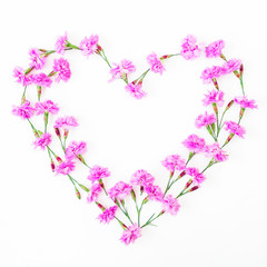 Fototapeta na wymiar Heart of pink flowers on white background. Flat lay, top view. Valentine's day. 