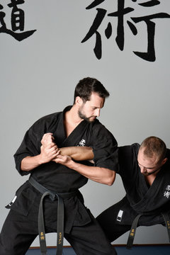 Martial arts fight position with kimono and black belts