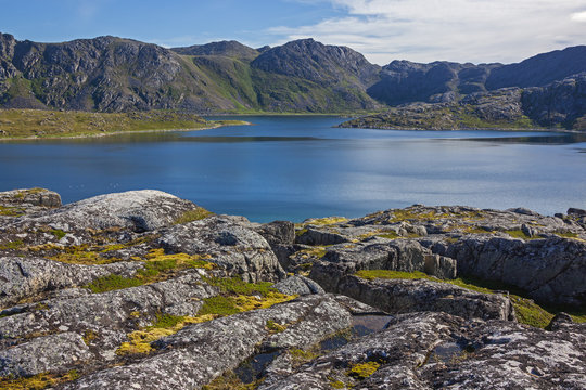 Magnificent mountain lake with the coast covered with moss. Short summer in Finnmark, Norway. Northernmost part of continental Europe
