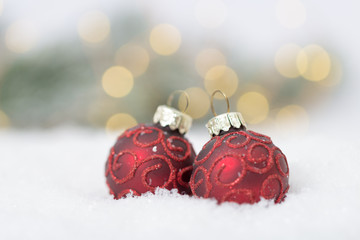 rote Christbaumkugeln im Schnee