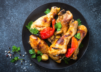 Grilled Chicken drumsticks on black bakground.