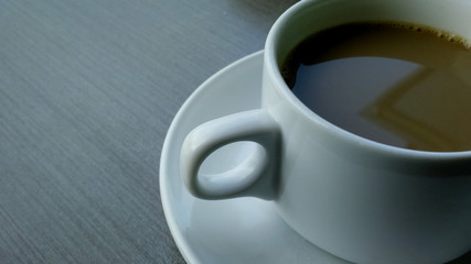 a cup of brown coffee on the wood textured table